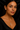 Woman wearing a necklace and earrings against a dark background